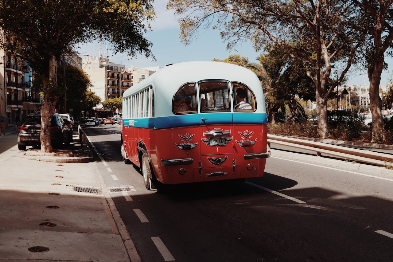 Classic Maltese bus driving through the streets of Valletta, capturing the retro charm of urban travel.